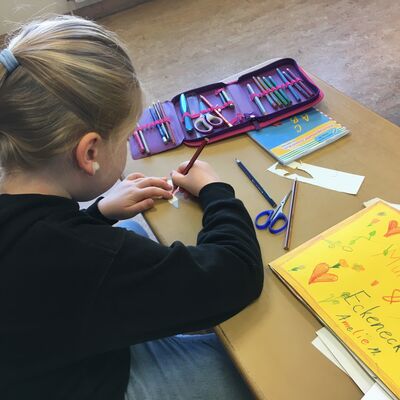 Bild vergr&ouml;&szlig;ern: Ein Kind hantiert mit Stift und Schere
